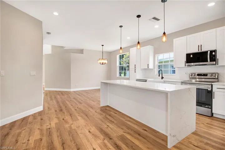 Kitchen featuring recessed lighting, a center island, stainless steel appliances, and light wood-type flooring