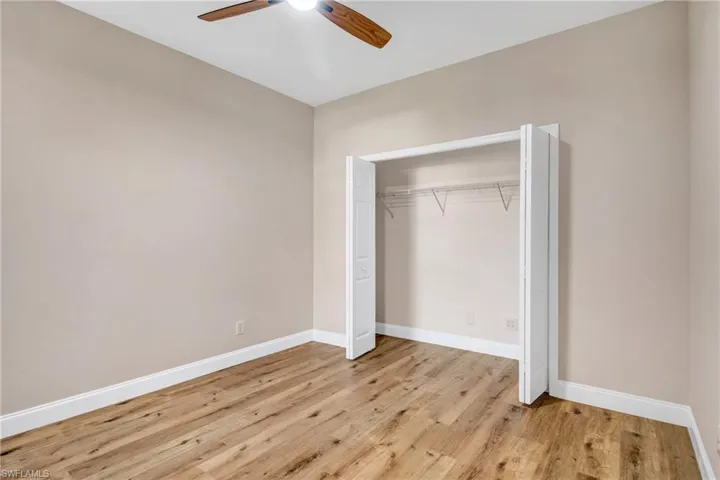 Unfurnished bedroom featuring light wood-style flooring, baseboards, a closet, and ceiling fan