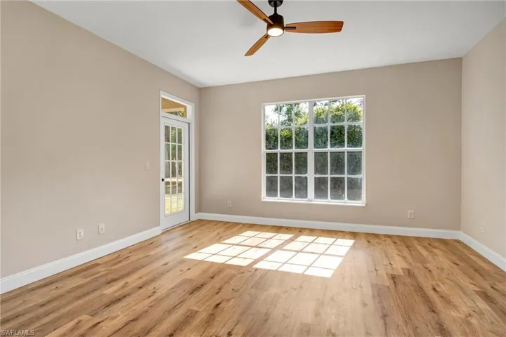 Empty room with light wood-type flooring, a ceiling fan, and baseboards