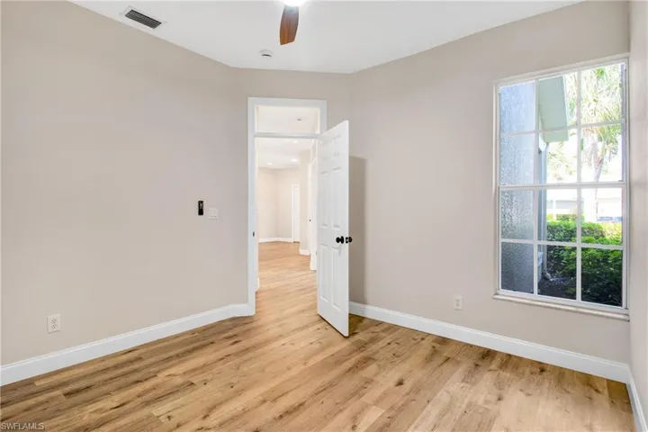 Unfurnished room featuring visible vents, light wood finished floors, baseboards, and ceiling fan