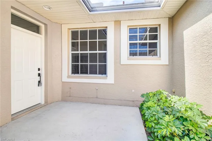 Doorway to property featuring stucco siding and a patio area