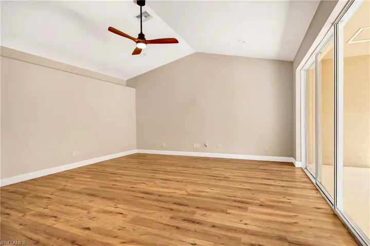 Unfurnished room with light wood-style flooring, visible vents, vaulted ceiling, and ceiling fan