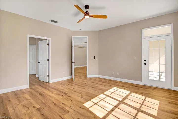 Unfurnished bedroom featuring light wood-type flooring, baseboards, a ceiling fan, and visible vents