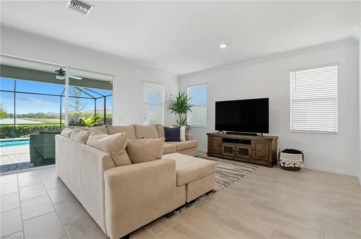 Living room with crown molding, a sunroom, recessed lighting, and wood tiled floors