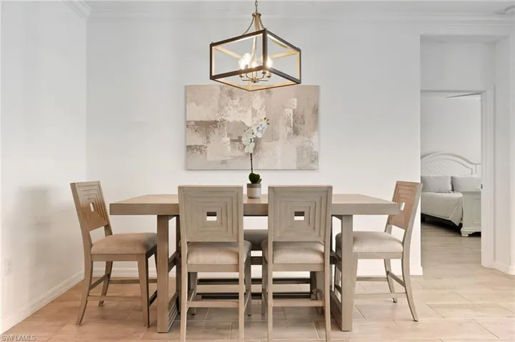 Dining room featuring ornamental molding, light wood-style floors, and a chandelier