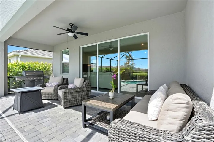 View of patio / terrace featuring an outdoor hangout area, ceiling fan, glass enclosure, and an outdoor pool