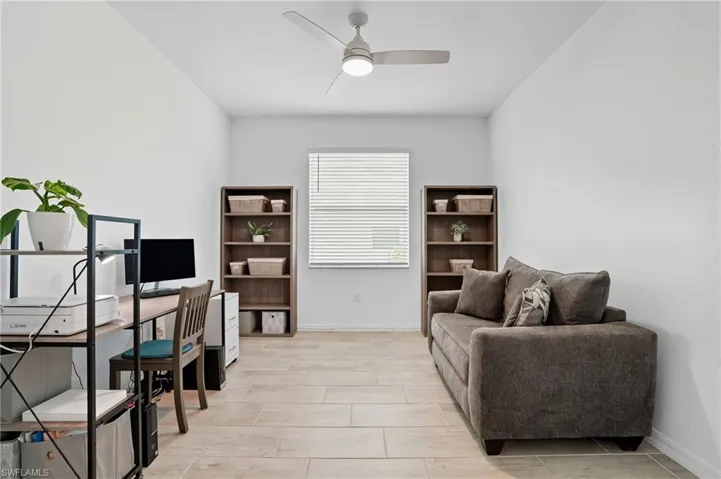 Office space with a ceiling fan and baseboards