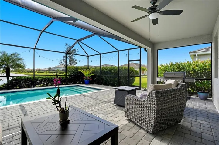 Swimming pool with a lanai, a ceiling fan, and a patio area