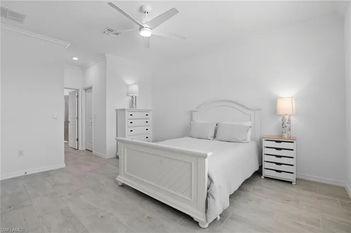 Bedroom featuring ornamental molding, a ceiling fan, and wood finish floors