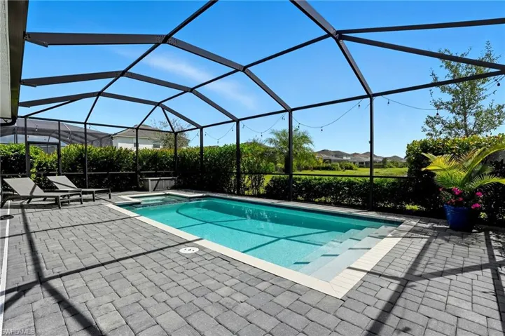 View of pool with a pool with connected hot tub, a lanai, a patio, and a sunroom