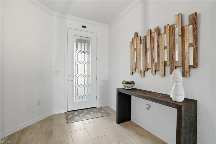 Foyer entrance with ornamental molding and light tile patterned floors