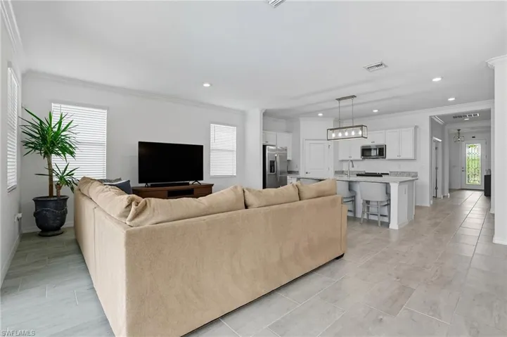Living area featuring ornamental molding and recessed lighting