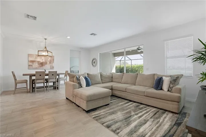 Living room featuring crown molding, light wood-type flooring, recessed lighting, and a ceiling fan