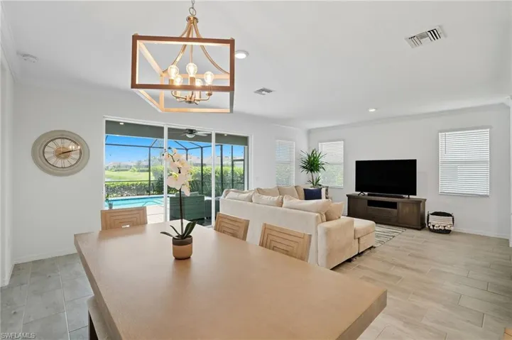 Dining space with ornamental molding, recessed lighting, a chandelier, and light wood-style flooring