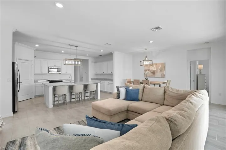 Living room featuring a chandelier, crown molding, recessed lighting, and light wood-type flooring