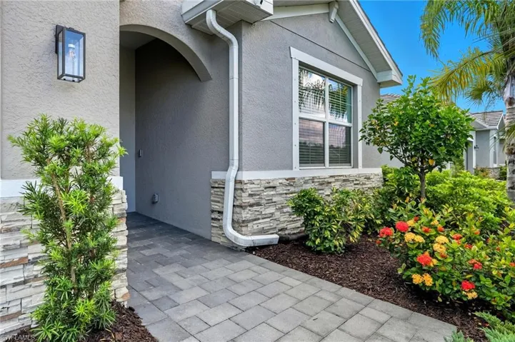 Entrance to property with stone siding and stucco siding