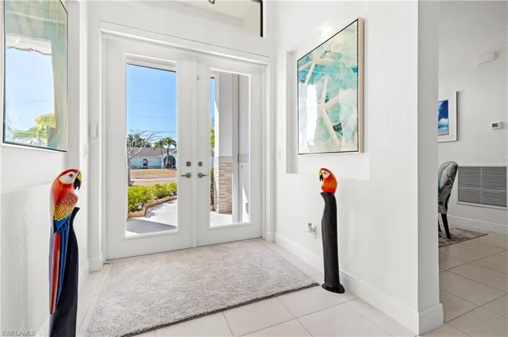 Entryway featuring light tile patterned floors and french doors