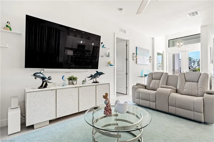 Tiled living area featuring suspended lighting and french doors