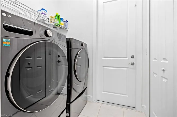 Laundry room featuring washing machine and dryer and tile patterned flooring