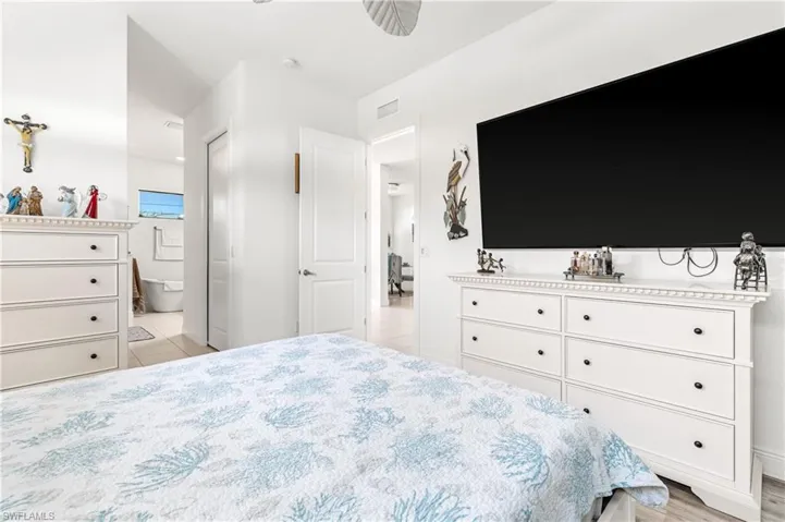Bedroom with a ceiling fan and ensuite bath