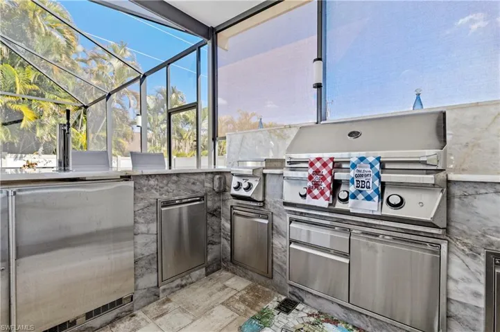 View of patio / terrace featuring glass enclosure, area for grilling, and a sunroom