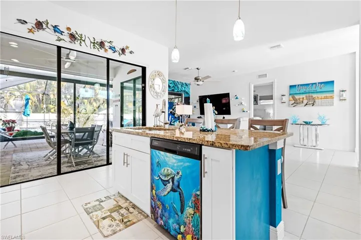 Kitchen featuring ceiling fan, light stone countertops, a breakfast bar, and light tile patterned floors