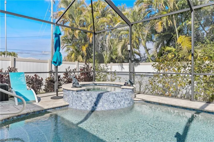 Integrated pool / hot tub with a lanai, a fenced backyard, and a sunroom