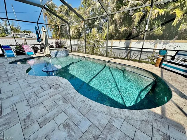 Integrated pool / hot tub featuring a fenced backyard, a sunroom, a lanai, and a patio