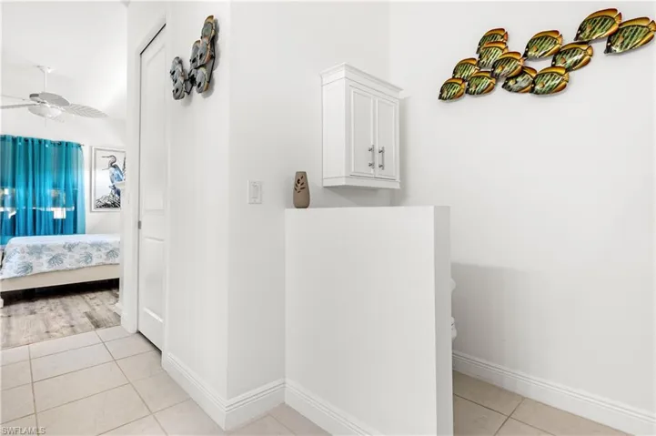 Corridor featuring light tile patterned floors and baseboards
