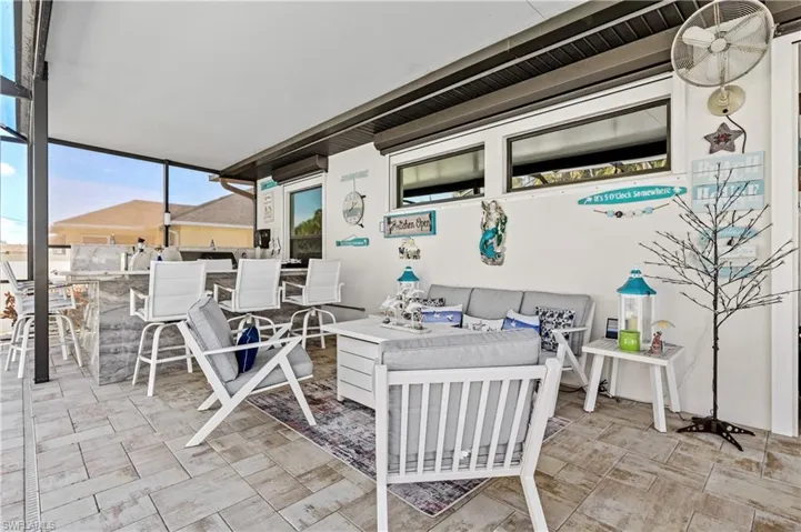 View of patio featuring a sunroom and an outdoor lounge area with bar