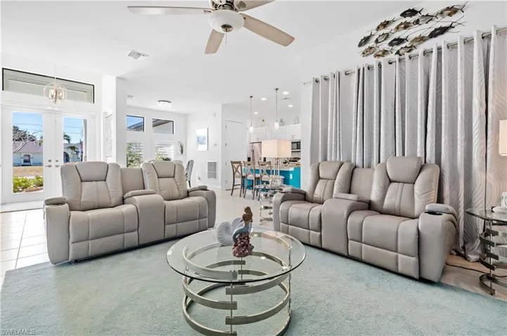 Carpeted living area with a ceiling fan and recessed lighting