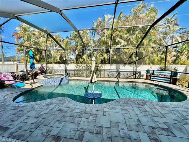 Combined pool / hot tub featuring a sunroom, a fenced backyard, and glass enclosure
