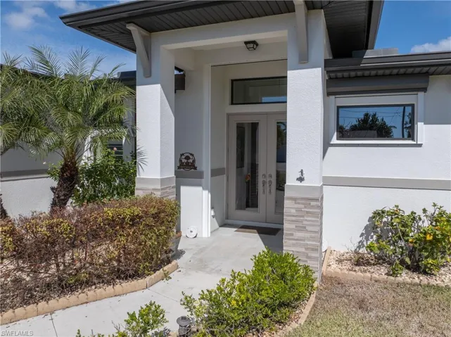 Property entrance featuring stucco siding and stone siding