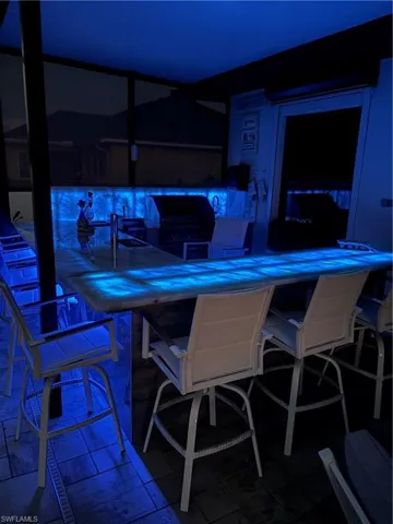 View of patio featuring a grill, a sunroom, and glass enclosure