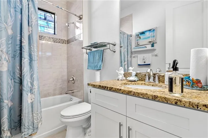 Bathroom featuring shower / bath combination with curtain and vanity