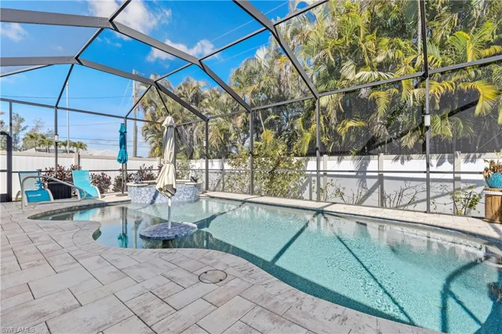 View of swimming pool featuring a fenced backyard, glass enclosure, and a sunroom