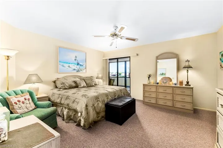 Carpeted bedroom featuring ceiling fan and access to exterior