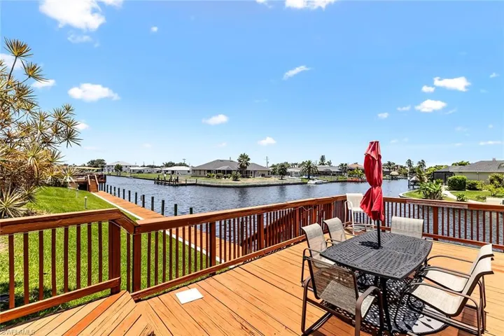 Wooden deck featuring a water view and a yard