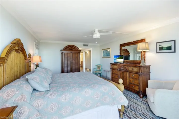 Bedroom with a ceiling fan and ornamental molding