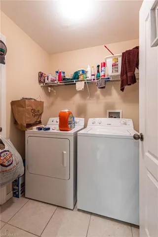 Laundry area featuring light tile patterned floors, washer and dryer, and laundry area