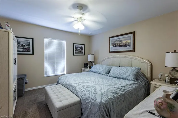 Bedroom with baseboards, carpet flooring, and a ceiling fan