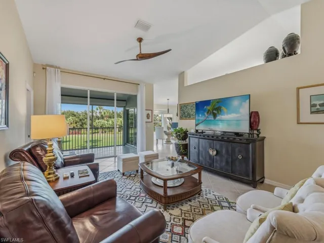 Living room with a ceiling fan and tile patterned flooring