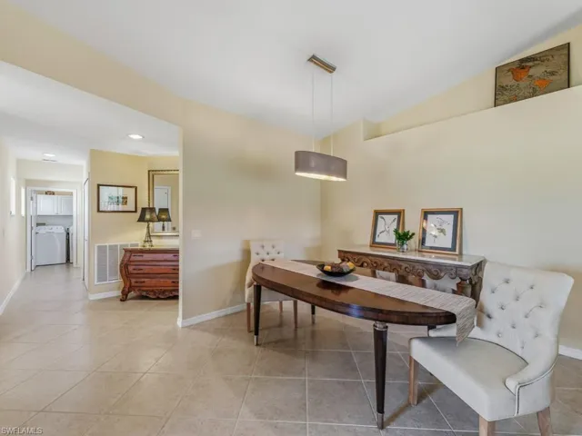 Dining space featuring light tile patterned floors, washer / dryer, lofted ceiling, and recessed lighting