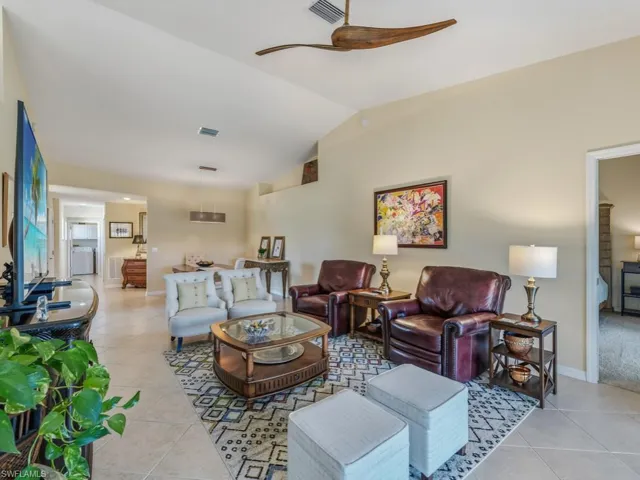 Living area featuring light tile patterned floors, lofted ceiling, and washer / clothes dryer