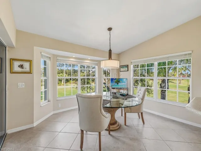 Dining space with light tile patterned floors, lofted ceiling, and healthy amount of natural light