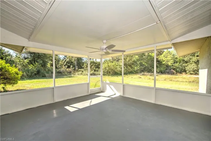 Unfurnished sunroom featuring ceiling fan and lofted ceiling
