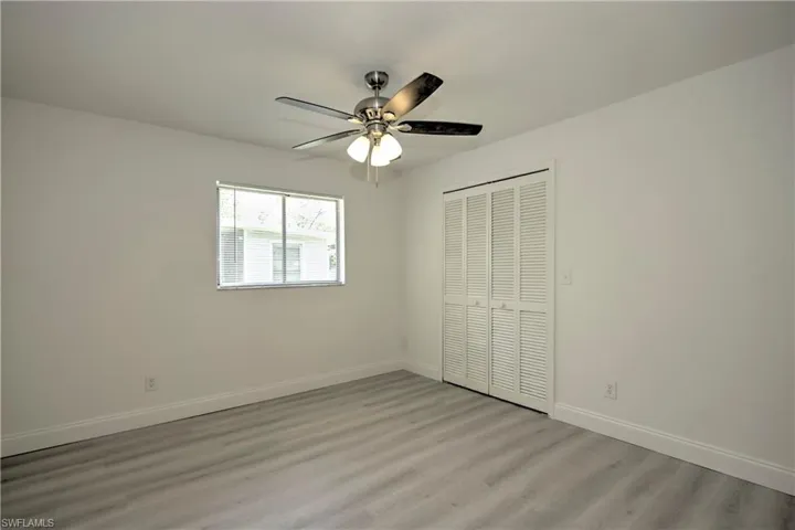 Unfurnished bedroom featuring light wood-type flooring, a closet, and ceiling fan