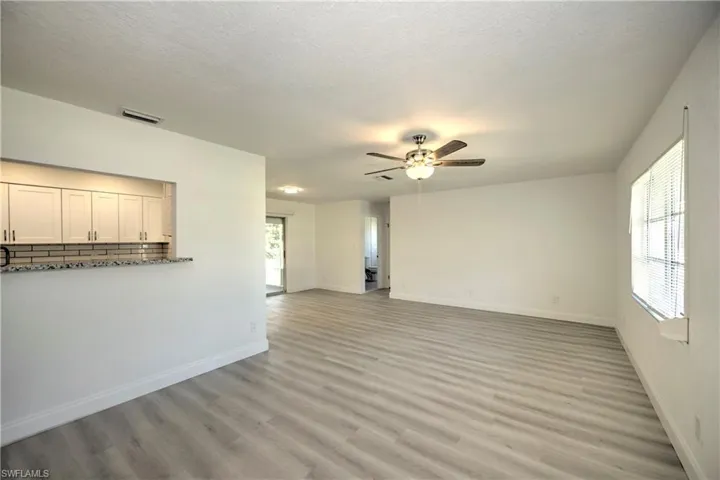 Unfurnished living room with ceiling fan, a textured ceiling, and light wood-type flooring