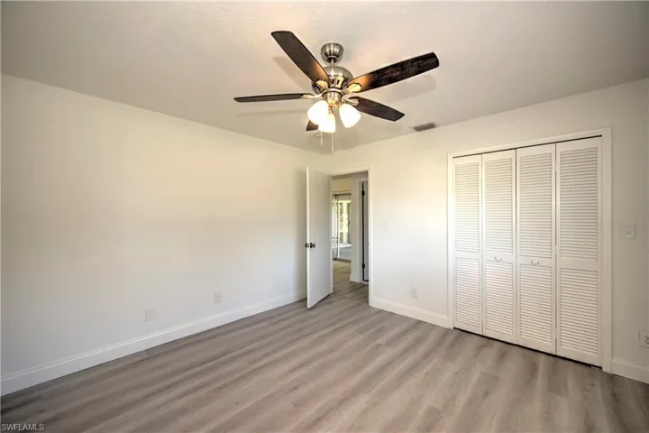 Unfurnished bedroom featuring ceiling fan, a closet, and light hardwood / wood-style flooring