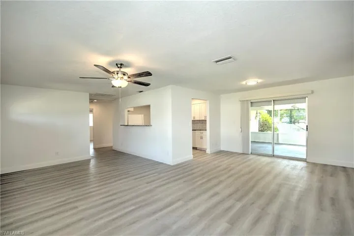 Unfurnished living room featuring ceiling fan, a textured ceiling, and light wood-type flooring